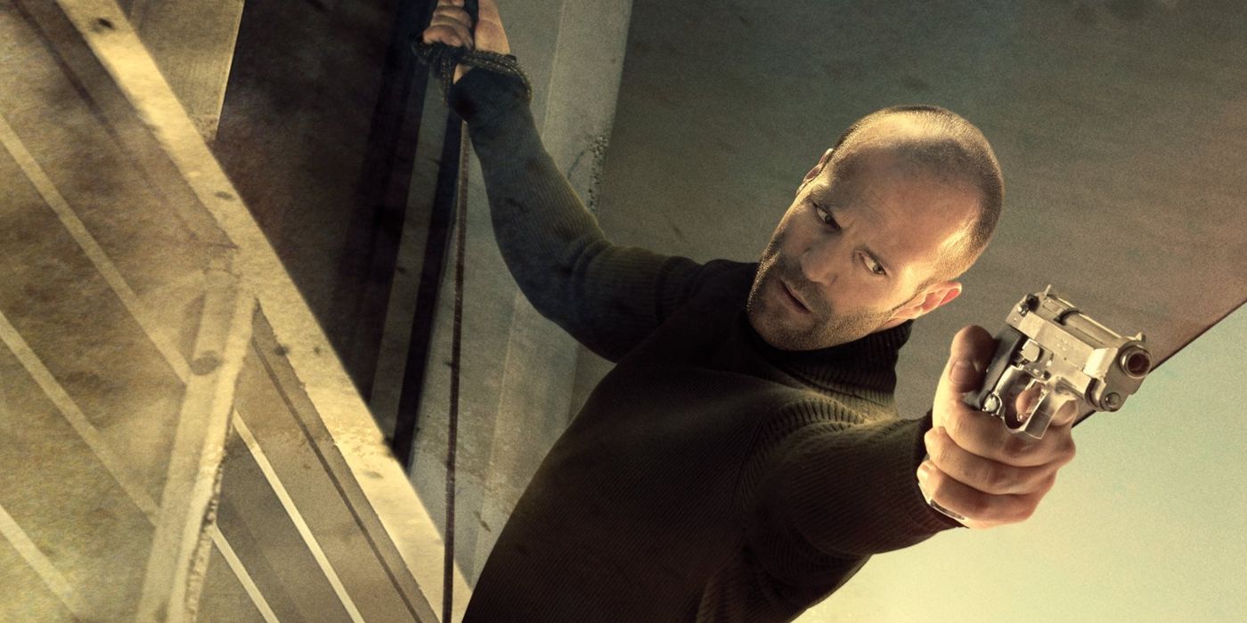 Jason Statham atarnand de o cladire si impuscand cu o arma in The Mechanic